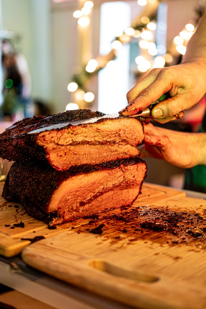 Juicy brisket being sliced on a wooden board, perfect for food lovers.
